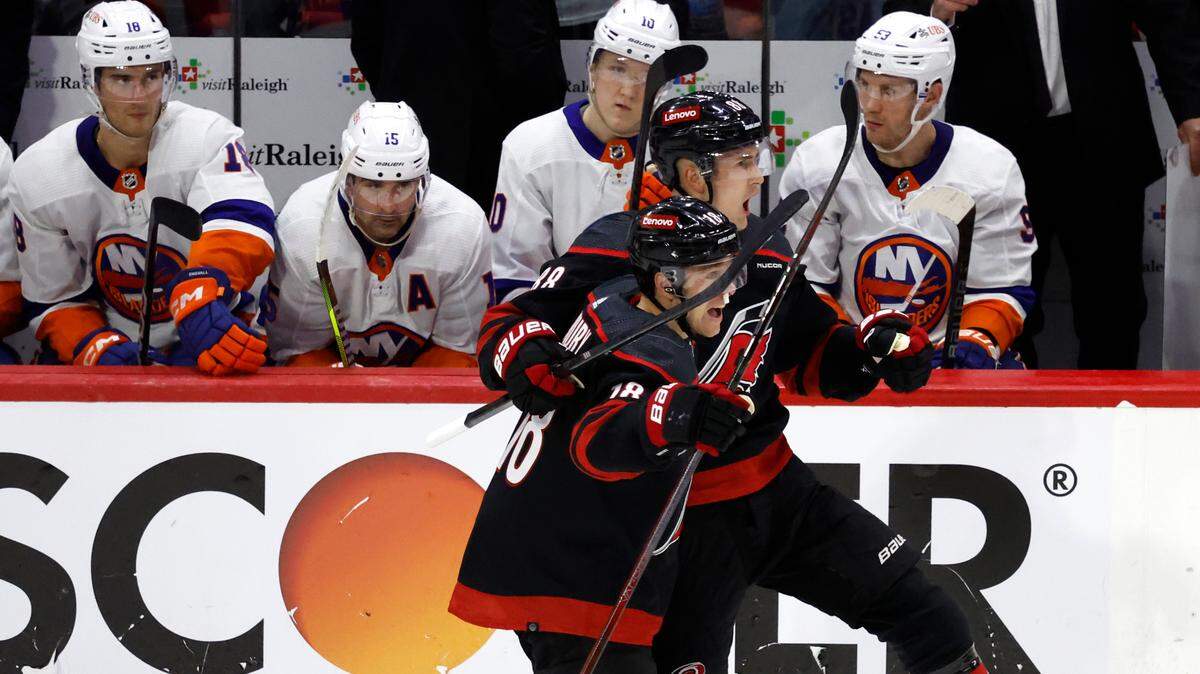 Carolina’s Martin Necas (88) and Jack Drury (18) celebrate after Necas scored on an empty netter during the third period of the Hurricanes 3-1 victory over the Islanders in the first round of the Stanley Cup playoffs at PNC Arena in Raleigh, N.C., Saturday, April 20, 2024.