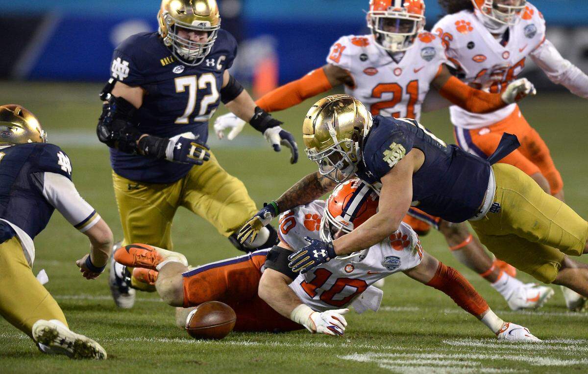 Clemson Tigers linebacker Baylon Spector, center and Notre Dame running back Kyren Williams, right, scramble to grab ahold of a fumble during the ACC Championship game. Notre Dame recovered the ball. Clemson defeated Notre Dame 34-10 to win the championship at Bank of America Stadium in Charlotte, NC on Saturday, December 19, 2020.  