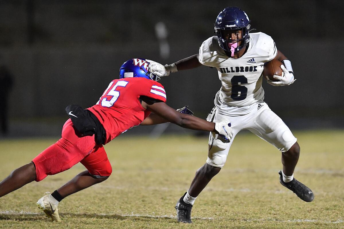 Millbrook running back Xavier Pugh (6) stiff-arms Wake Forest’s Andre Evans (15) during the second half. The Wake Forest Cougars and the Millbrook Wildcats met in a football game in Wake Forest, N.C. on October 28, 2022.