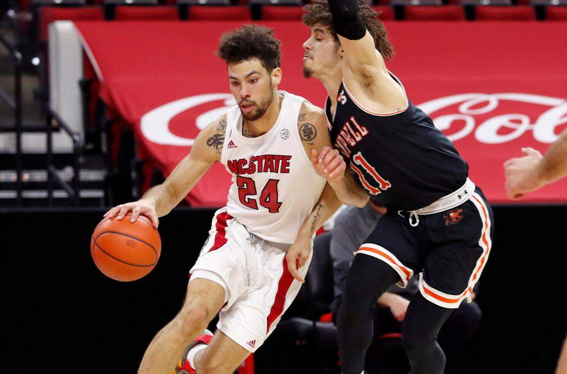 N.C. State’s Devon Daniels (24) drives around Campbell’s Jordan Whitfield (11) during the first half of N.C. State’s game against Campbell at PNC Arena in Raleigh, N.C., Saturday, Dec. 19, 2020.