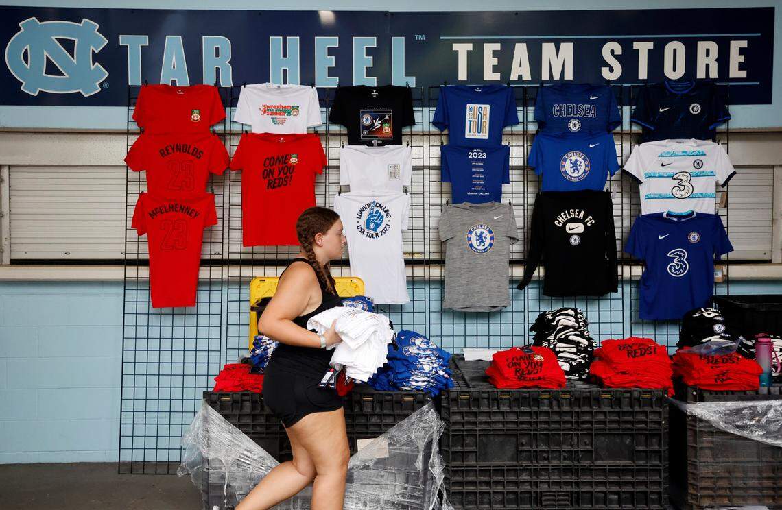 Sara Chipam sets up the t-shirt sales area before Chelsea FC’s international friendly match against Wrexham FC at Kenan Stadium in Chapel Hill, N.C., Wednesday, July 19, 2023.