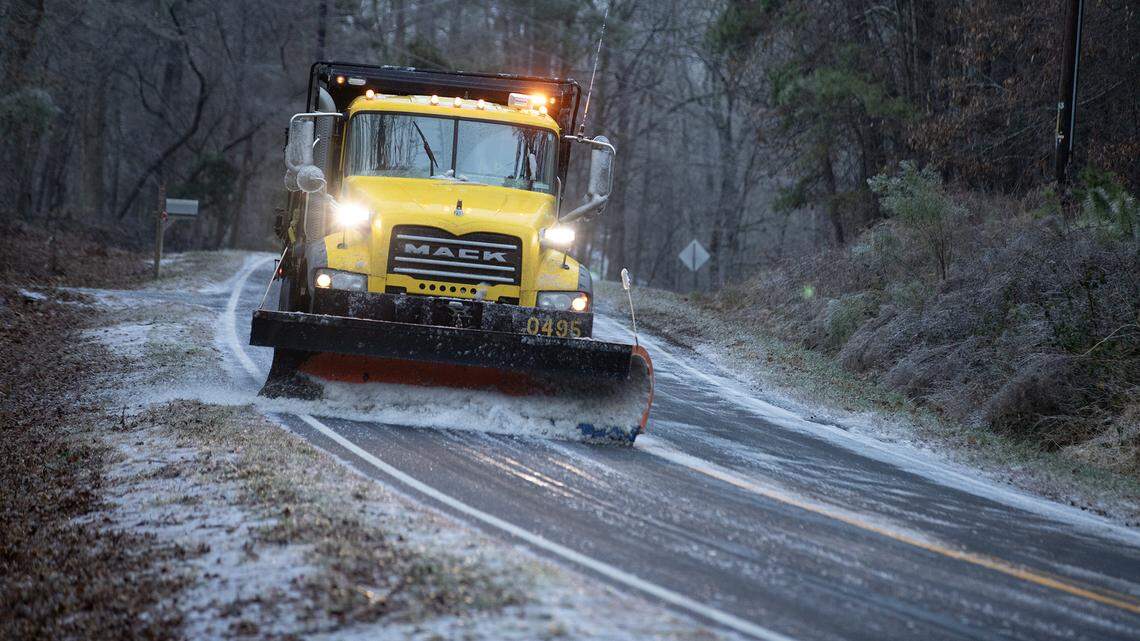 A DOT plow scrapes ice from the steep surface of Penny Road, south of Downtown Raleigh, Saturday morning.