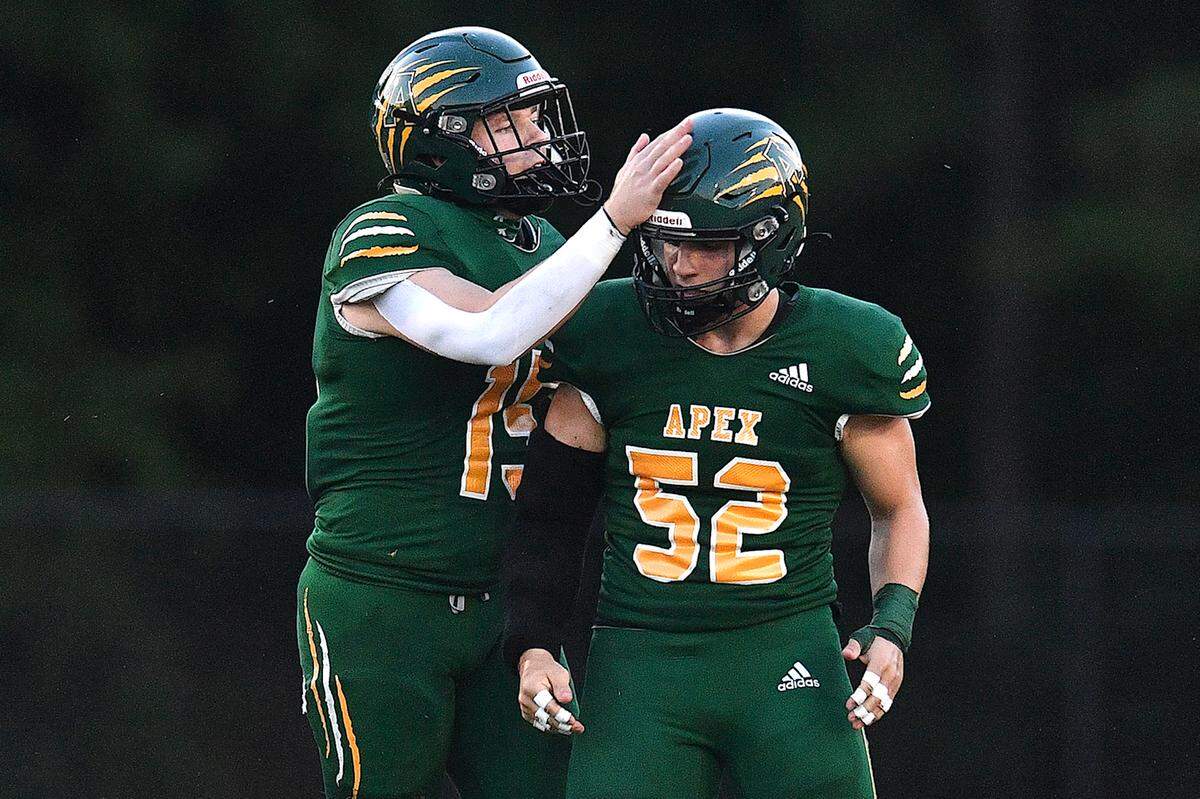 Apex’s Cade Earl celebrates with Rocco Paolillo (52) after a play against Panther Creek during the first half. The Apex Cougars and the Panther Creek Catamounts met in a conference football game in Apex, N.C. on September 20, 2024.