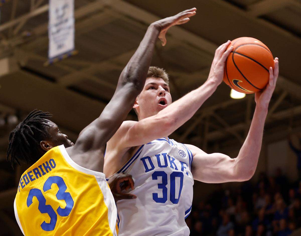 Duke’s Kyle Filipowski is fouled while driving to the basket past Pittsburgh’s Federiko Federiko during the first half of a men’s basketball game at Cameron Indoor Stadium on Wednesday, Jan. 11, 2023, in Durham, N.C.
