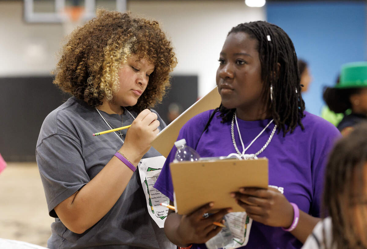 Brooklyn, left, uses a clipboard to organize her expenses during the “Stacks” portion of Stacks and Tracks.