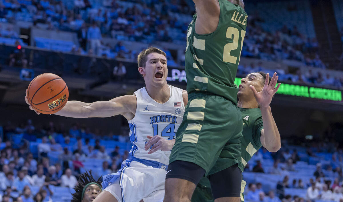 North Carolina guard Angelo Brizzi (14) passes around UNC Charlotte forward Miguel Allen (21) in the first half on Tuesday, October 27, 2026 at the Smith Center in Chapel Hill, N.C.