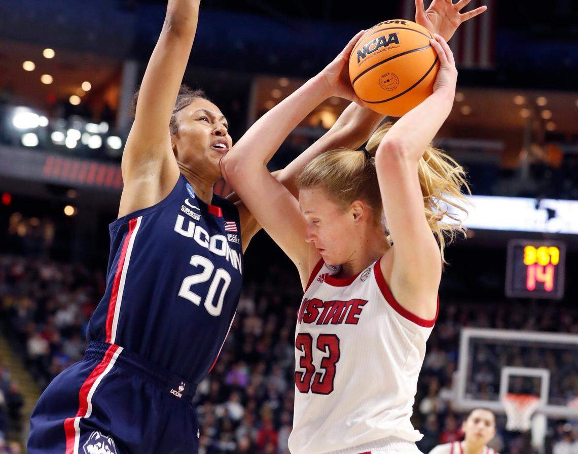 N.C. State’s Elissa Cunane (33) looks for room as Connecticut’s Olivia Nelson-Ododa (20) defends during the first half of N.C. States game against the University of Connecticut in the Bridgeport Regional final at Total Mortgage Arena in Bridgeport, Conn., Monday, March 28, 2022.