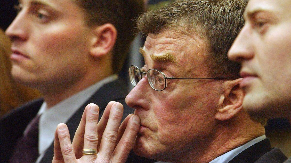 Michael Peterson sits in the back row in a courtroom of the Durham County Judicial Building between sons Clayton (left) and Todd as they await his name to be called during court proceeding Tuesday morning.