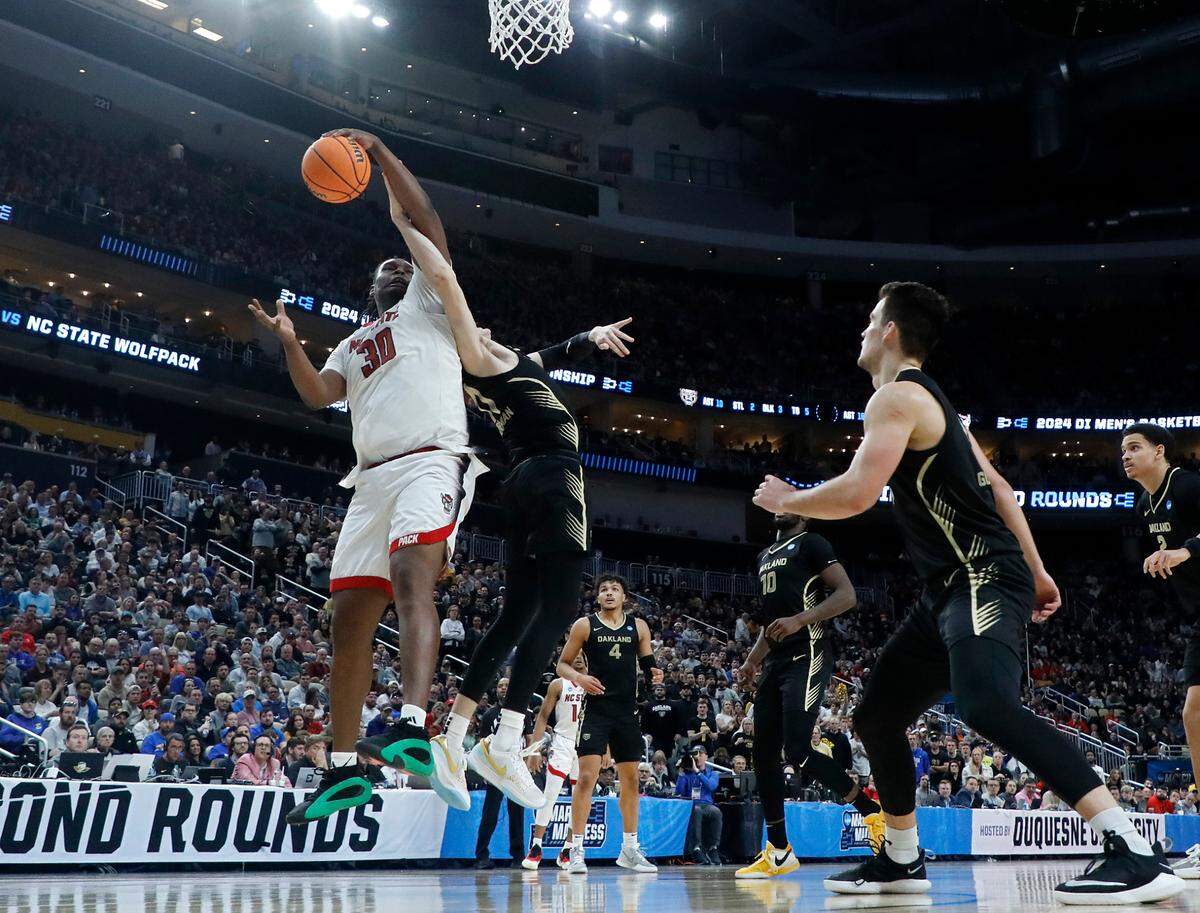 N.C. State’s DJ Burns Jr. pulls down a rebound in front of Oakland’s Blake Lampman during the second half of the Wolfpack’s 79-73 overtime win in the second round of the NCAA Tournament on Saturday, March 23, 2024, at PPG Paints Arena in Pittsburgh, Pa.