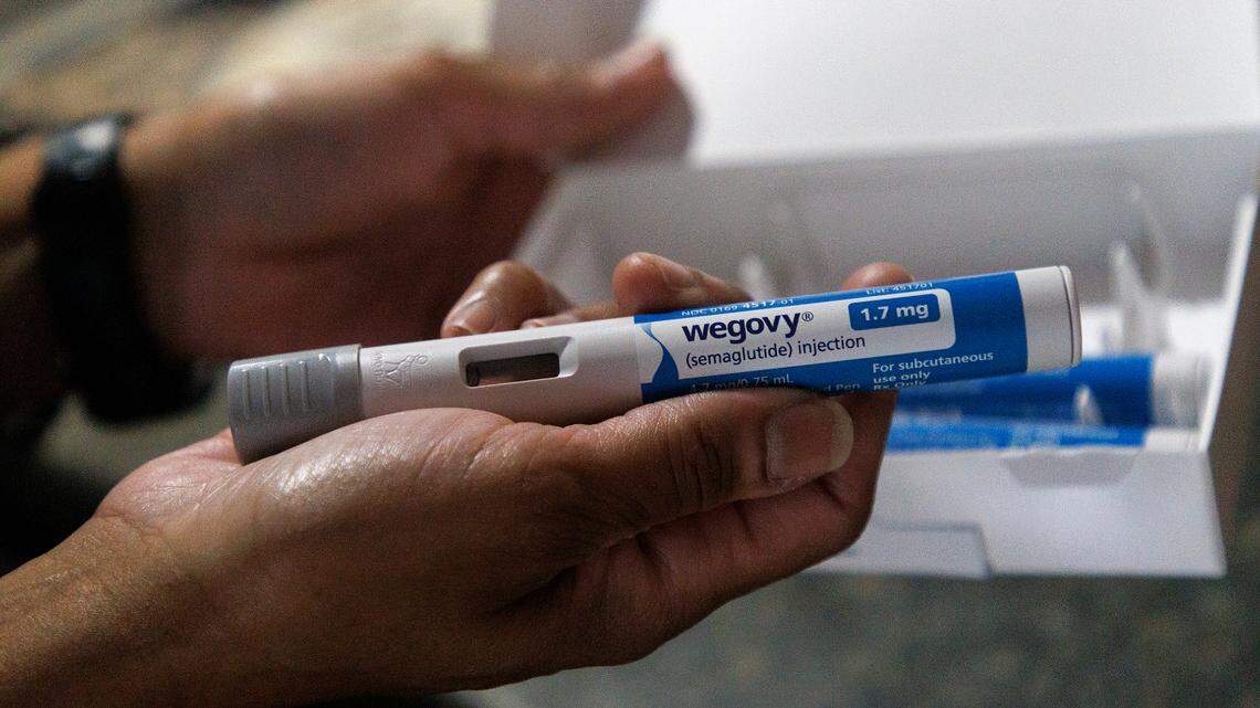 Tralene Williams, a state employee of 18 years, holds a Wegovy pen prior to administering a once weekly injection on Wednesday, Jan. 31, 2024, in Knightdale, N.C. Leaders of the State Health Plan voted to cut coverage beginning April 1 of all obesity GLP-1 medications, including Wegovy.