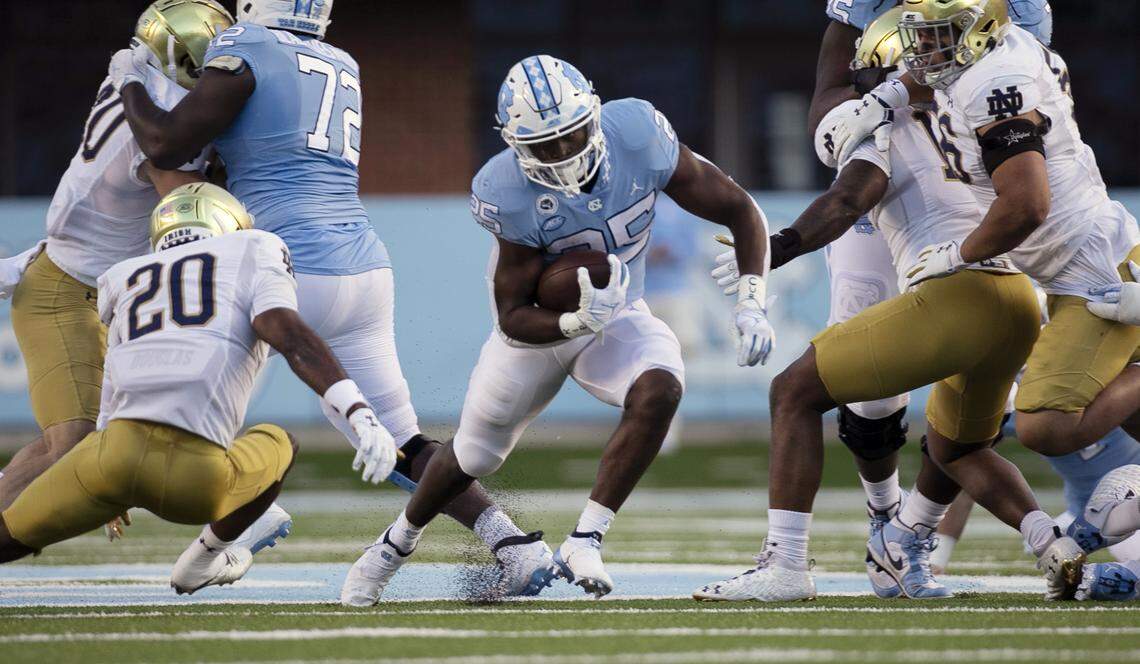 North Carolina’s Javonte Williams (25) breaks away from Notre Dame’s Shaun Crawford (20) in the first quarter on Friday, November 27, 2020 at Kenan Stadium in Chapel Hill, N.C.