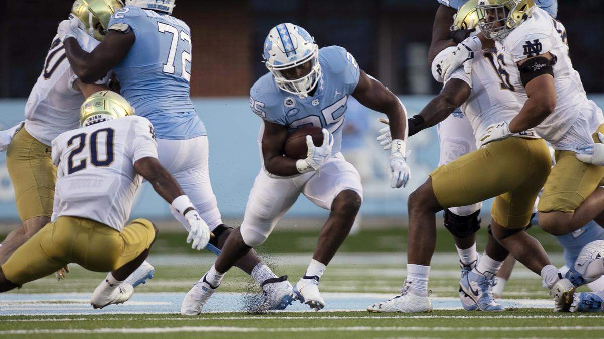North Carolina’s Javonte Williams (25) breaks away from Notre Dame’s Shaun Crawford (20) in the first quarter on Friday, November 27, 2020 at Kenan Stadium in Chapel Hill, N.C.