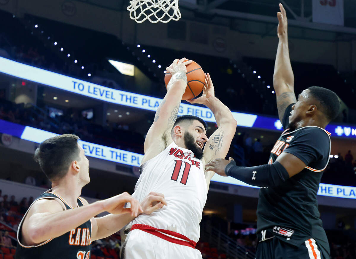 North Carolina State Wolfpack forward Dusan Mahorcic pulls down a rebound in front of Campbell Fighting Camels forward Jesus Carralero and guard Devon Dunn during the second half of a men’s basketball game at PNC Arena in Raleigh, N.C. on Friday, Nov. 11, 2022.