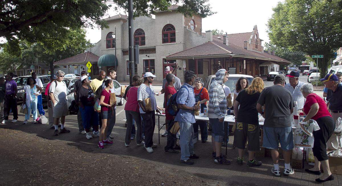 Millbrook Baptist Church serves hot sausage biscuits to the hungry and needy as they line up on the sidewalk in Moore Square at Martin Street on August 31, 2013 in Raleigh, N.C. The church prepared nearly 200 biscuits to distribute along with granola bars, coffee and toiletry items.