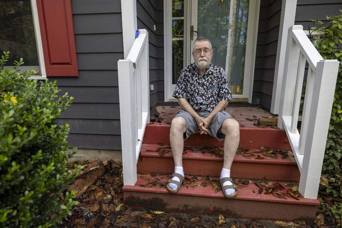 Peter Burke sits on the stoop of his flood damaged home in the Weatherhill Pointe neighborhood of Carrboro, N.C. on Friday August 15, 2025. Burke is waiting for repairs to be completed on his home after sustaining flood damage from Tropical Storm Chantal in July 2025.