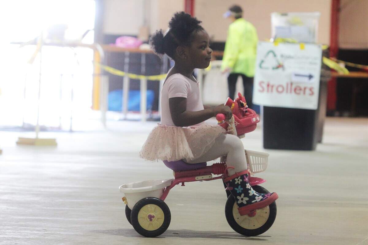 Hadassah Bumba takes her new tricycle for a spin during the Kids Exchange consignment sale Saturday at the NC State Fairgrounds.