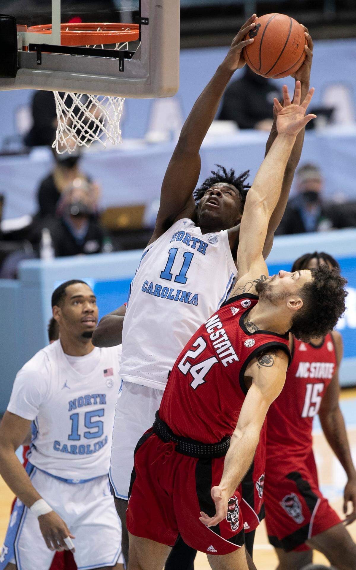 North Carolina’s DayÕRon Sharpe (11) secures an offensive rebound over NC State’s Devon Daniels (24) on Saturday, January 23, 2021 at the Smith Center in Chapel Hill, NC.