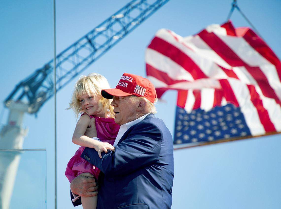 Former President Donald Trump holds his granddaughter Carolina during a rally in Wilmington, N.C., Saturday, Sept 21, 2024.