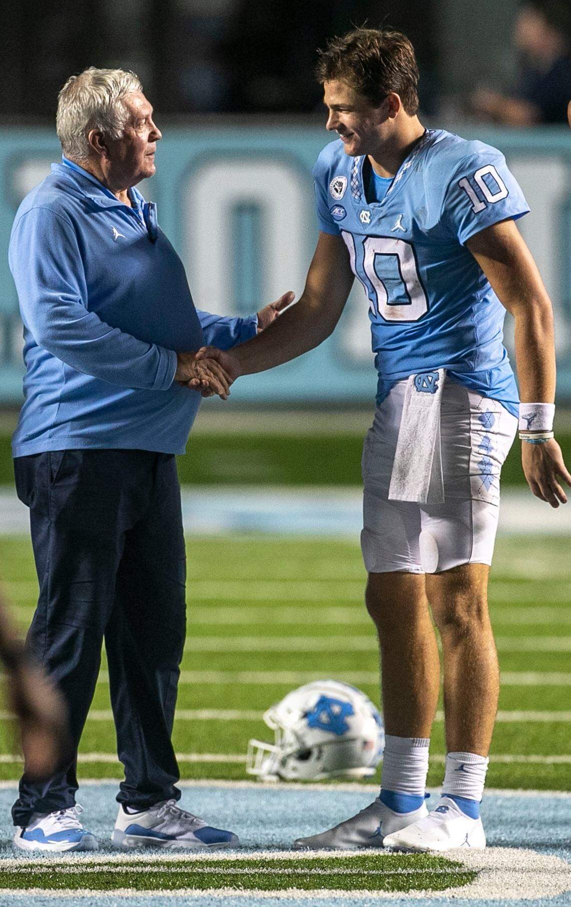 North Carolina coach Mack Brown congratulates quarterback Drake Maye (10) following the Tar Heels 56-24 victory over Florida A&M on Saturday, August 27, 2022 at Kenan Stadium in Chapel Hill, N.C. Maye passed for 294 yards and five touchdowns in the victory.
