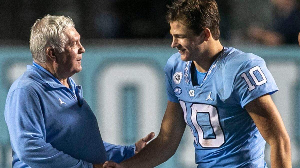 North Carolina coach Mack Brown congratulates quarterback Drake Maye (10) following the Tar Heels 56-24 victory over Florida A&M on Saturday, August 27, 2022 at Kenan Stadium in Chapel Hill, N.C. Maye passed for 294 yards and five touchdowns in the victory.