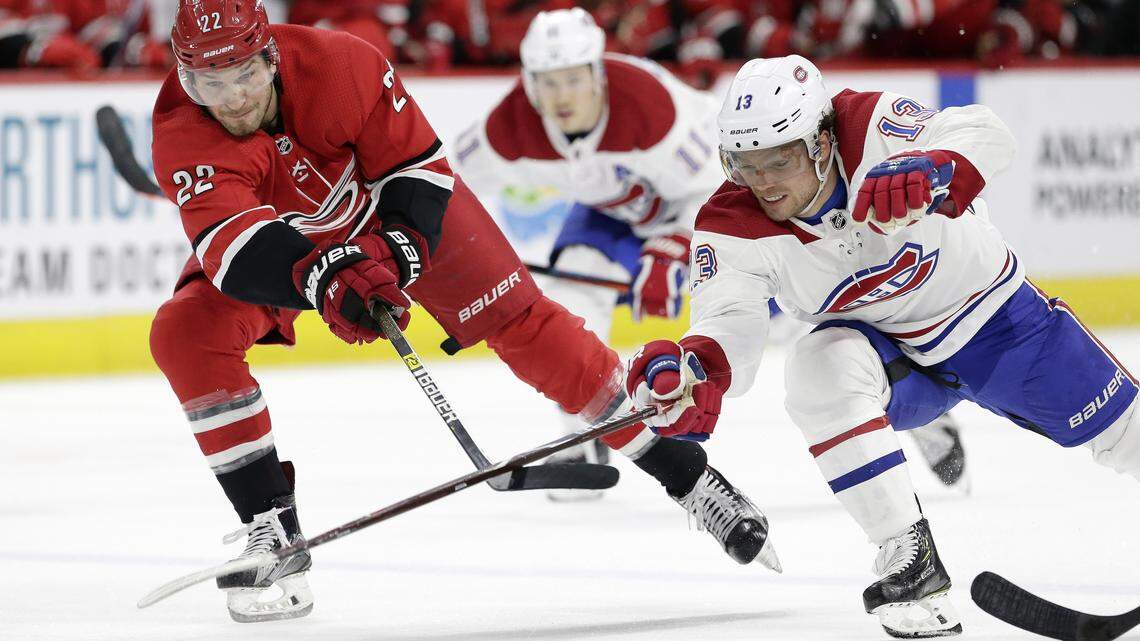 Carolina Hurricanes’ Brett Pesce (22) and Montreal Canadiens’ Max Domi (13) chase the puck during the second period of an NHL hockey game in Raleigh, N.C., Sunday, March 24, 2019.