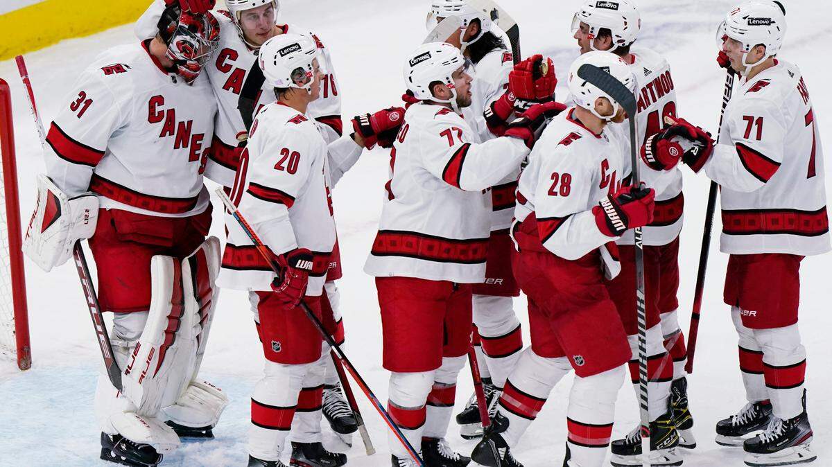 Carolina Hurricanes goaltender Frederik Andersen, left, celebrates with teammates after the Hurricanes defeated the Chicago Blackhawks 4-3 in an NHL hockey game in Chicago, Wednesday, Nov. 3, 2021. (AP Photo/Nam Y. Huh)
