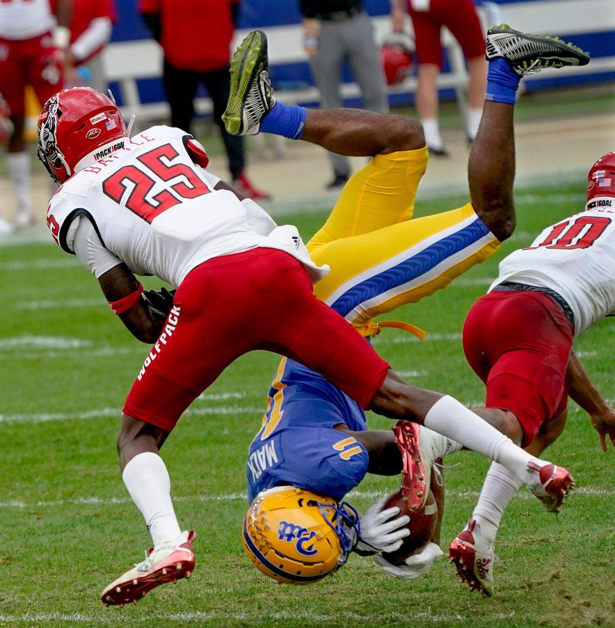 Pittsburgh wide receiver Taysir Mack (11) is upended as he is hit by North Carolina State cornerback Shyheim Battle (25) and safety Tanner Ingle after making a catch during the second half of an NCAA college football game, Saturday, Oct. 3, 2020, in Pittsburgh.