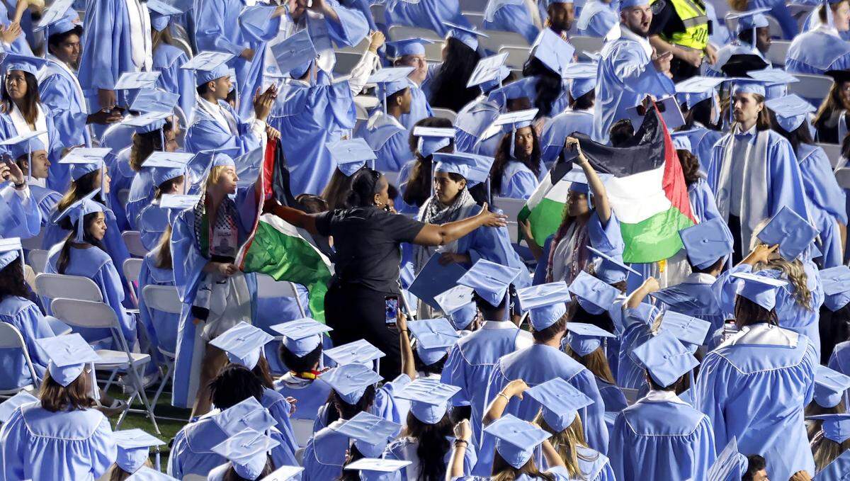 Palestinian flags are taken from protesters as they walk out of UNC Chapel Hill’s commencement ceremonies at Kenan Stadium in Chapel Hill, N.C., Saturday, May 11, 2024.