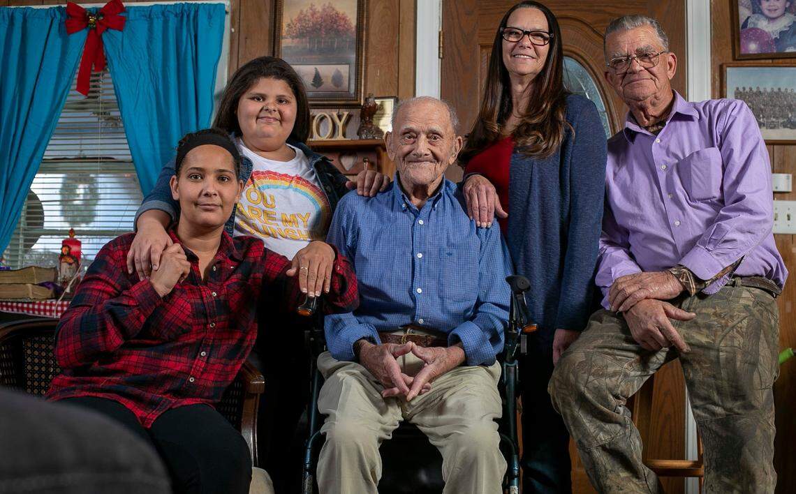 Five generations of the Lumbee Tribe, from left,Tracie Watson, great-granddaughter, Allie Grace Watson, great-great granddaughter, patriarch of the family Evert Locklear, age 102, Patti Ingram, granddaughter and Panuel Locklear, Evert’s son, pose for a family portrait in the Locklear home on Tuesday, November 30, 2021.