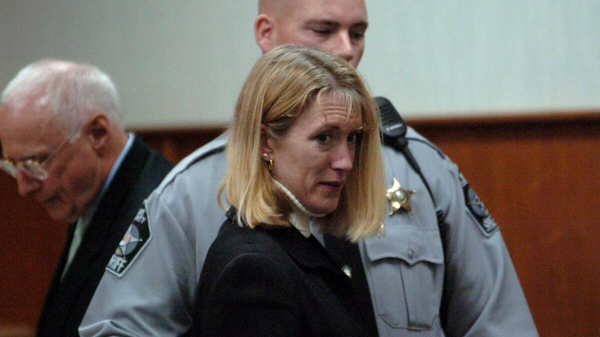 Ann Miller Kontz, center, is escorted out of a Wake County courtroom after she pled guilty to 2nd degree murder on November 7, 2005. She was convicted of poisoning her husband Eric Miller and will serve a minimum of 25 years in prison.  At left is one of her attorneys, Wade Smith.