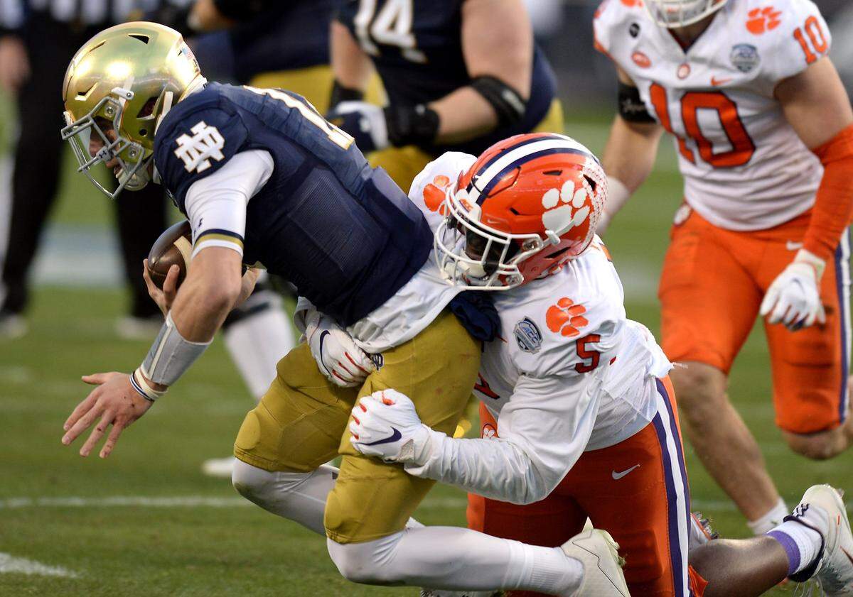 Clemson Tigers defensive end K.J. Henry, right, sacks Notre Dame quarterback Ian Book, left, during second quarter action at Bank of America Stadium on Saturday, December 19, 2020 in Charlotte, NC. The Clemson Tigers and Notre Dame Fighting Irish faced off in the ACC Championship game.