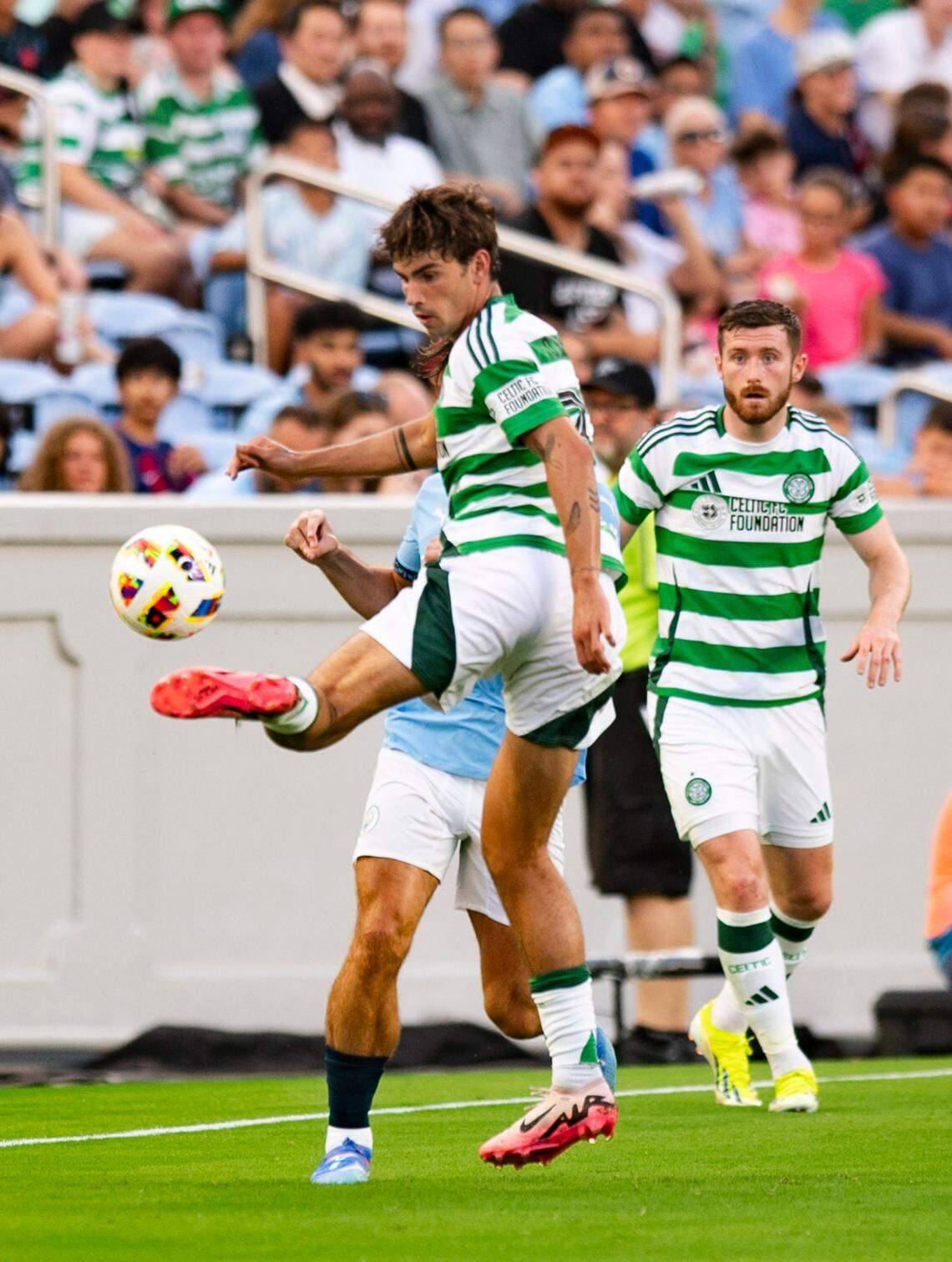 Celtic FC midfielder Matt O’Riley (33) works to gain possession of the ball during the Celtic FC vs Manchester City at Kenan Stadium in Chapel Hill on Tuesday, July 23, 2024. Celtic FC won 4-3.