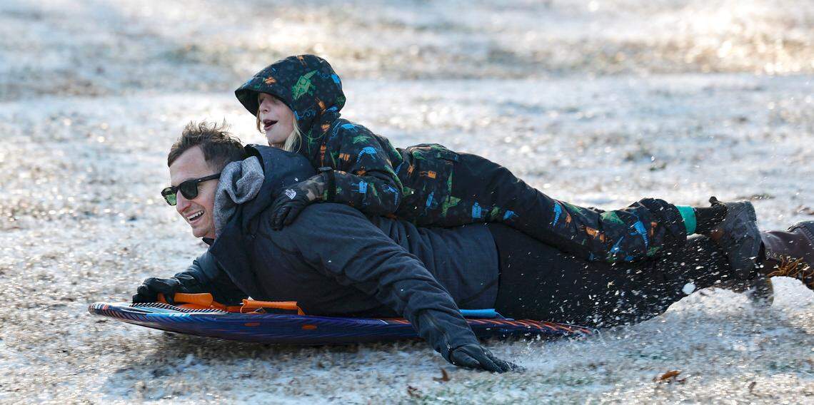 Paolo Rosa and his son Alesso, 8, sled down the hill at Dix Park in Raleigh, N.C., Saturday morning, Jan. 11, 2025.