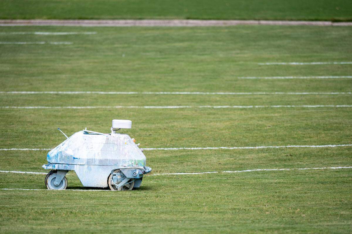 Cooper Boyce operates the paint robot to paint the class photo numbers (2027) on Duke University’s East Campus
