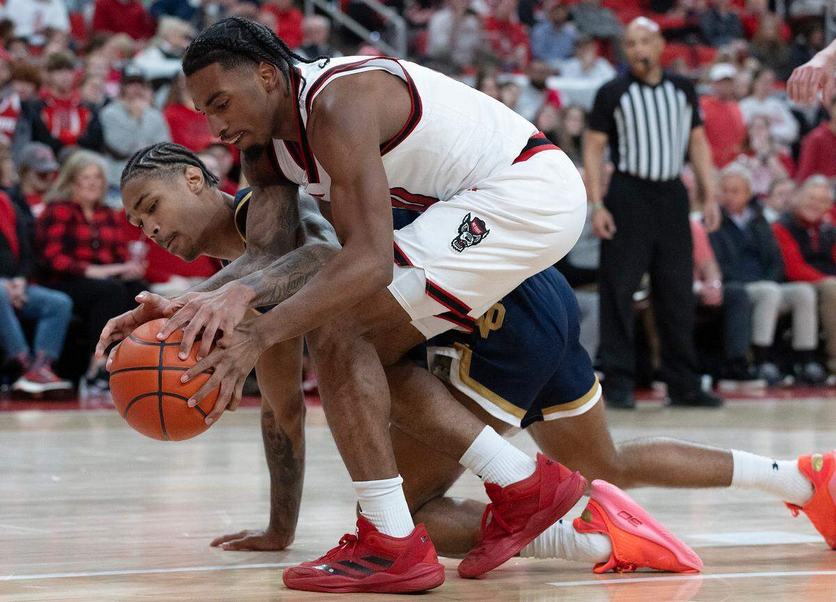 N.C. State’s Marcus Hill and Notre Dame’s Tae Davis scramble for a loose ball during the second half of the Wolfpack’s 66-65 win on Wednesday, Jan. 8, 2025, at Lenovo Center in Raleigh, N.C.