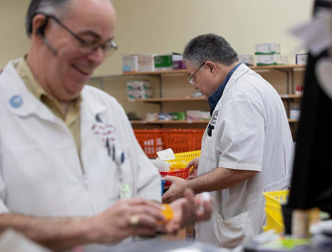 Pharmacists Keith and Kevin Layne, twin brothers and founders of Layne’s Family Pharmacy, work on Wednesday, Aug. 14, 2024, in Eden, N.C.