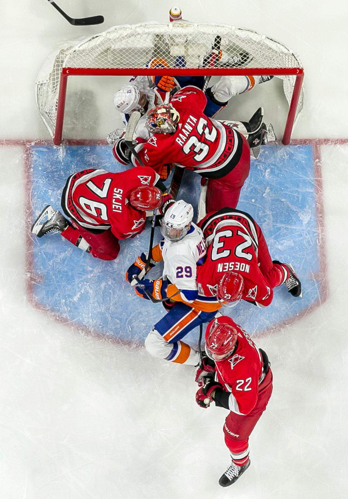 New York Islanders’ Kyle Palmeri (21) gets caught in the goal under Carolina Hurricanes’ goalie Antii Raanta (32) during the first period during in Game 2 of their Stanley Cup series on Wednesday, April 19, 2023 at PNC Arena in Raleigh, N.C.