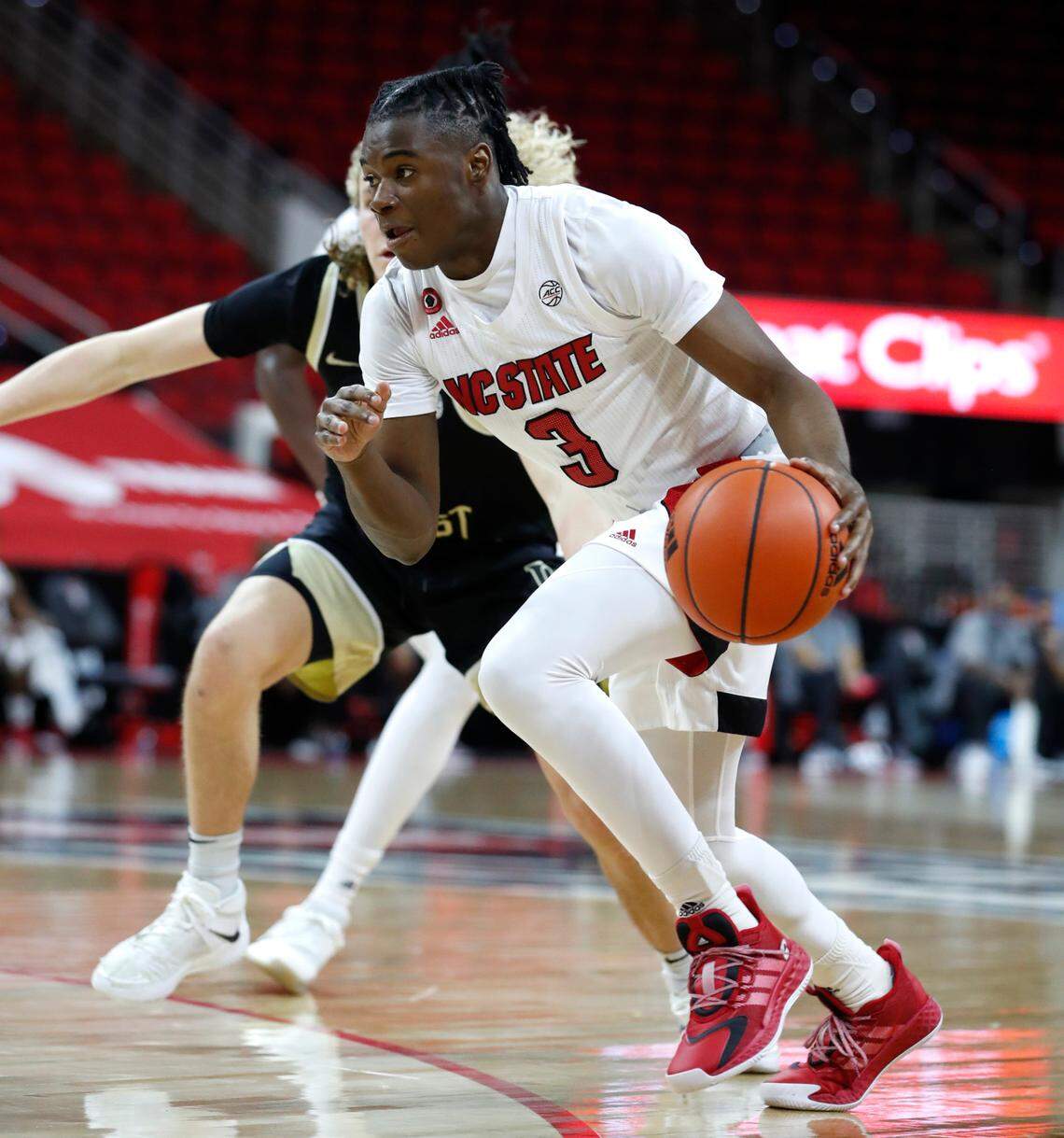 N.C. State’s Cam Hayes (3) drives around Wake Forest’s Carter Whitt (35) during the first half of N.C. State’s game against Wake Forest at PNC Arena in Raleigh, N.C., Wednesday, January 27, 2021.