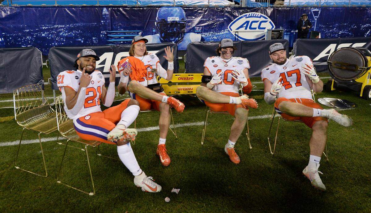 Clemson Tigers quarterback Trevor Lawrence, second from left and his teammates enjoy sitting in the gold chairs the the Notre Dame Fighting Irish used on their sidelines during the ACC Championship game. Clemson defeated Notre Dame 34-10 to win the championship at Bank of America Stadium in Charlotte, NC on Saturday, December 19, 2020.