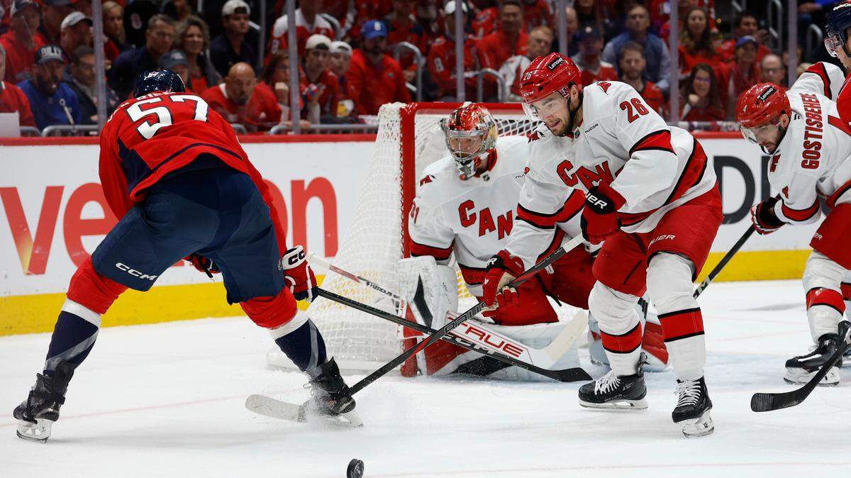 Carolina Hurricanes defenseman Sean Walker (26) clears the puck from in front of Hurricanes goaltender Frederik Andersen (31) as Washington Capitals defenseman Trevor van Riemsdyk (57) reaches in the first period in game two of the second round of the 2025 Stanley Cup Playoffs at Capital One Arena.