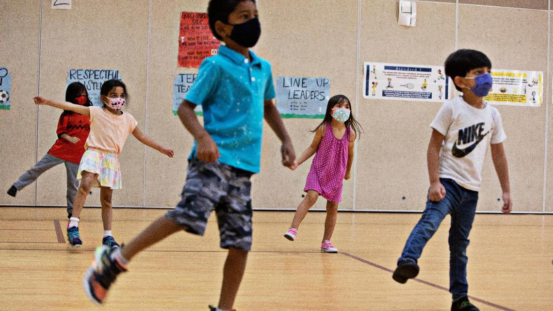 Kindergartners are spread out during P.E. at Carpenter Elementary School in Cary on Thursday morning, Aug. 19, 2021. Rules such as keeping their face masks on have been a learning curve for some new and returning students at year-round schools like Carpenter Elementary.