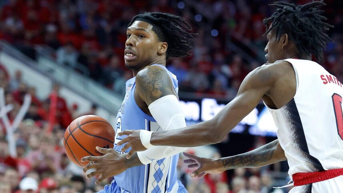 North Carolina’s Caleb Love (2) drives by N.C. State’s Terquavion Smith (0) during the first half of N.C. State’s game against UNC at PNC Arena in Raleigh, N.C., Sunday, Feb. 19, 2023.