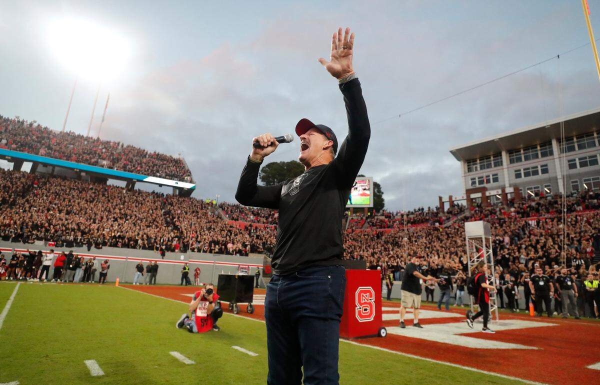 Former N.C. State linebacker Bill Cowher leads the crowd in a Wolfpack chant before the Wolfpack’s game against Louisville at Carter-Finley Stadium in Raleigh, N.C., Friday, Sept. 29, 2023.
