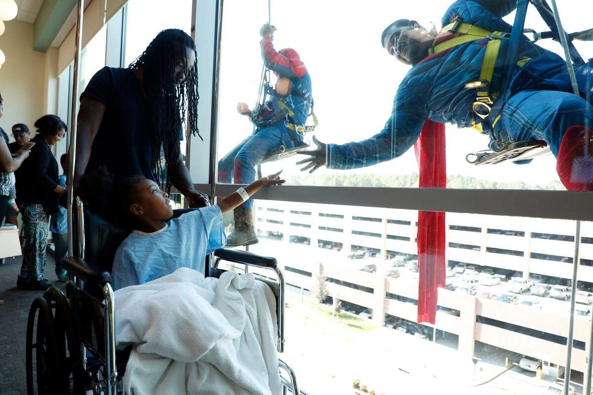 Kyler Spears, 5, and her father, Brandon, say hello to Superman, played by Miguel Aguilar, at WakeMed Children’s Hospital in Raleigh, N.C., Friday, October 4, 2019. The photo took first place for feature photography among the state’s largest newspapers in the North Carolina Press Association’s annual awards.