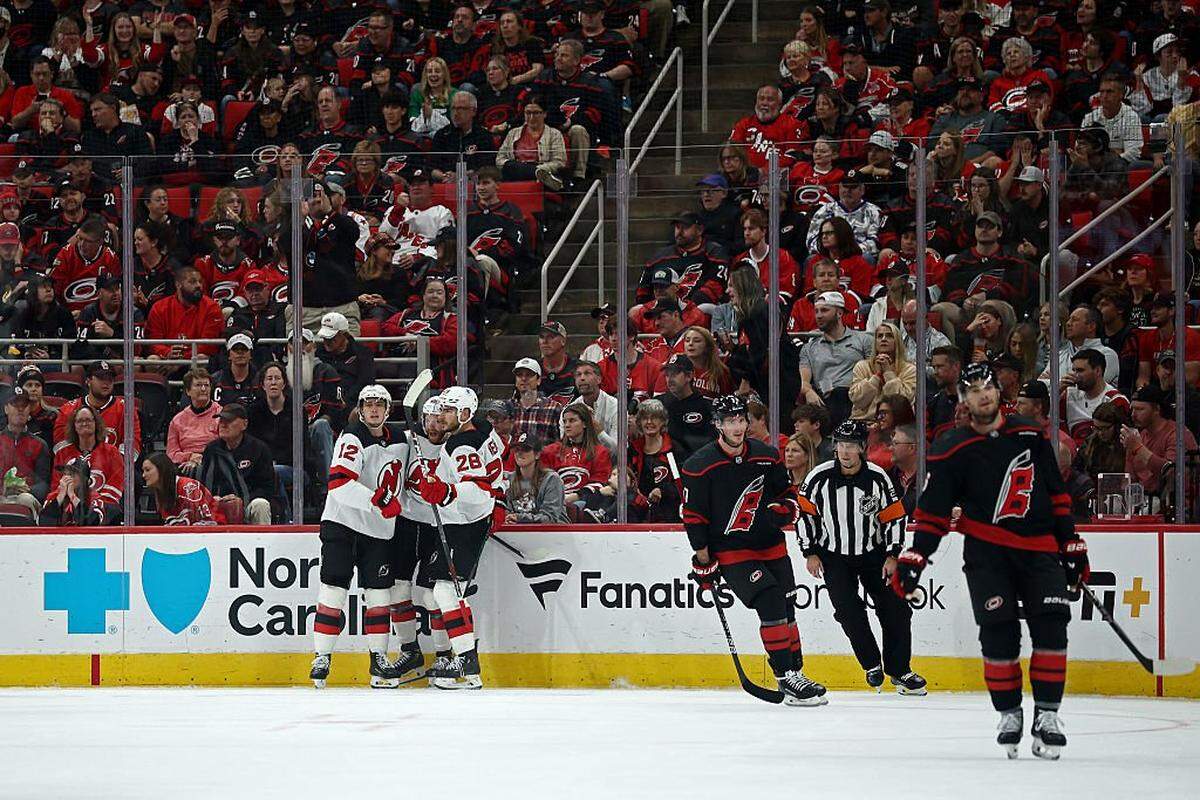 Cody Glass of the New Jersey Devils celebrates with his teammates following a goal scored during the second period of the game against the Carolina Hurricanes at Lenovo Center on October 09, 2025 in Raleigh, North Carolina.
