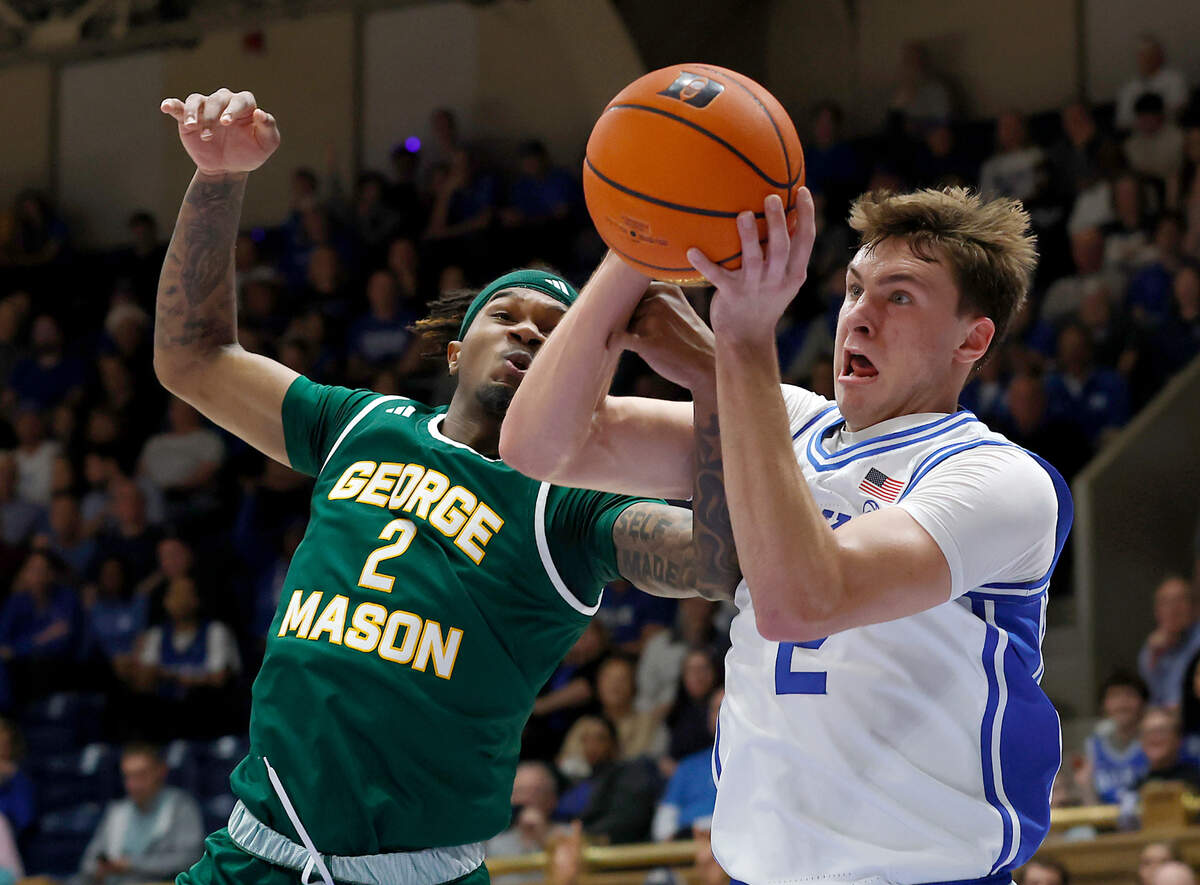 George Mason’s Woody Newton and Duke’s Cooper Flagg battle for a loose ball during the first half of the Blue Devils’ game on Tuesday, Dec. 17, 2024, at Cameron Indoor Stadium in Durham, N.C.