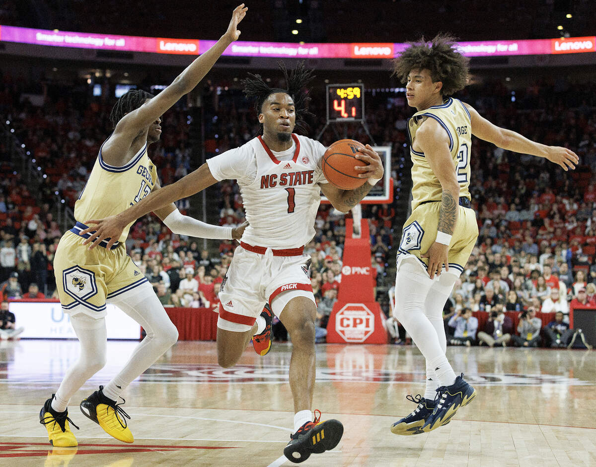 N.C. State’s Jayden Taylor drives between Georgia Tech’s Miles Kelly and Naithan George during the first half of the Wolfpack’s game on Saturday, Feb. 3, 2024, at PNC Arena in Raleigh, N.C.