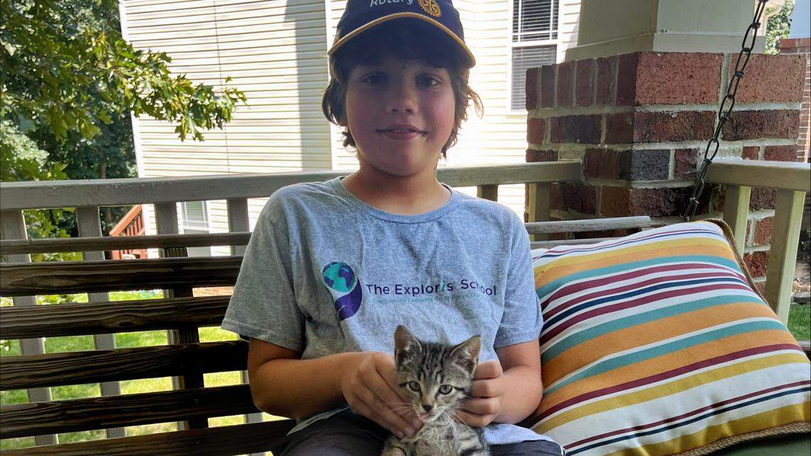 Felix Averitte holds Georgie, the kitten he and his father found in a storm drain. Raleigh firefighters pulled the cat to safety with PVC pipe and rope.