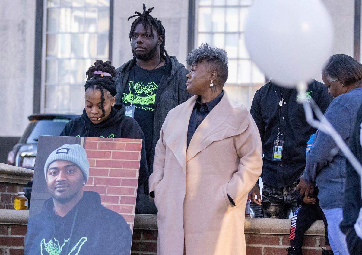During a Day of Remembrance for Gun-Related Homicide Victims ceremony in Durham Friday, Dec. 30, 2022, gun violence prevention advocates from Bull City United, from left, Latisha Williamson, Mario Melvin and Keshia Gray stand with a photograph of Reshaun Cates who was found shot to death in his car off Interstate 85 near Hillandale Road in October.