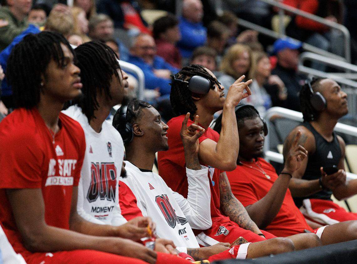 N.C. State’s Ernest Ross, center, acknowledges Wolfpack fans while watching Oakland vs. Kentucky with teammates during the first round of the NCAA Tournament on Thursday, March 21, 2024, at PPG Paints Arena in Pittsburgh, Pa.